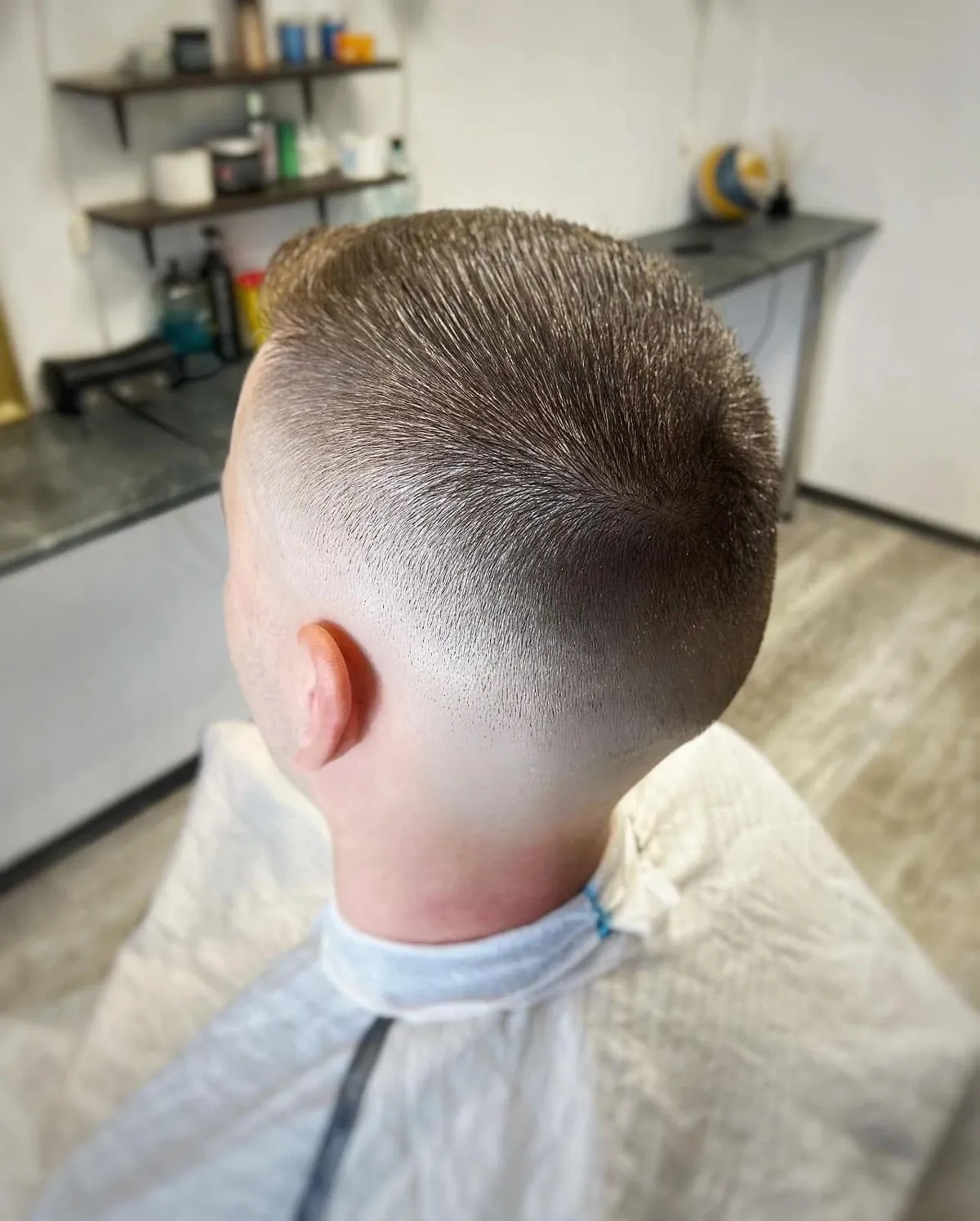 Īss vīriešu fade griezums no mugurpuses – gluda pāreja pie kakla